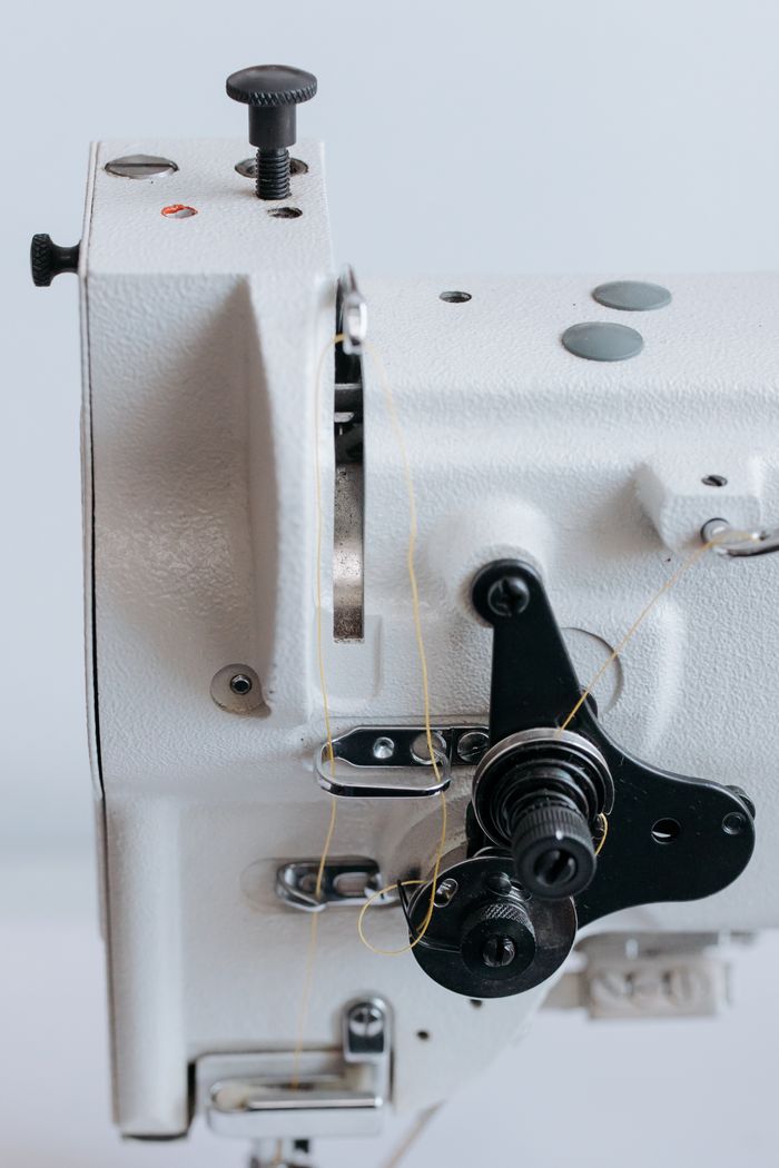 Crafting Captivating Headlines: Your awesome post title goes here Detailed view of industrial sewing machine components showcasing mechanical parts and threads.