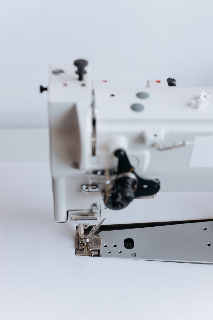 services-03 Detail of industrial sewing machine showing metal components and knobs.